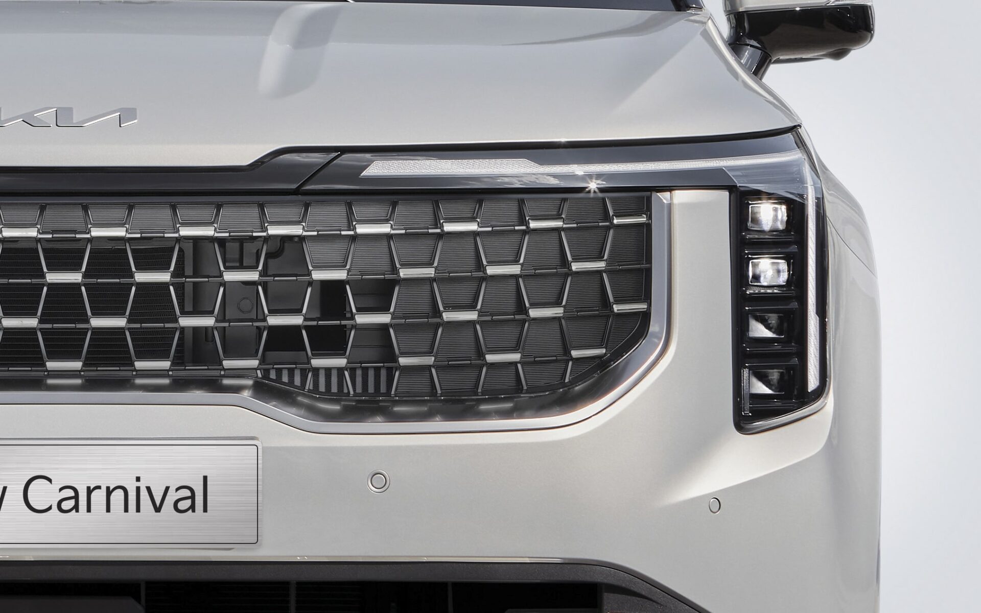KIA Carnival - Thiết kế mới mở rộng bề thế, đan xen họa tiết lục giác mạ Chrome cao cấp.